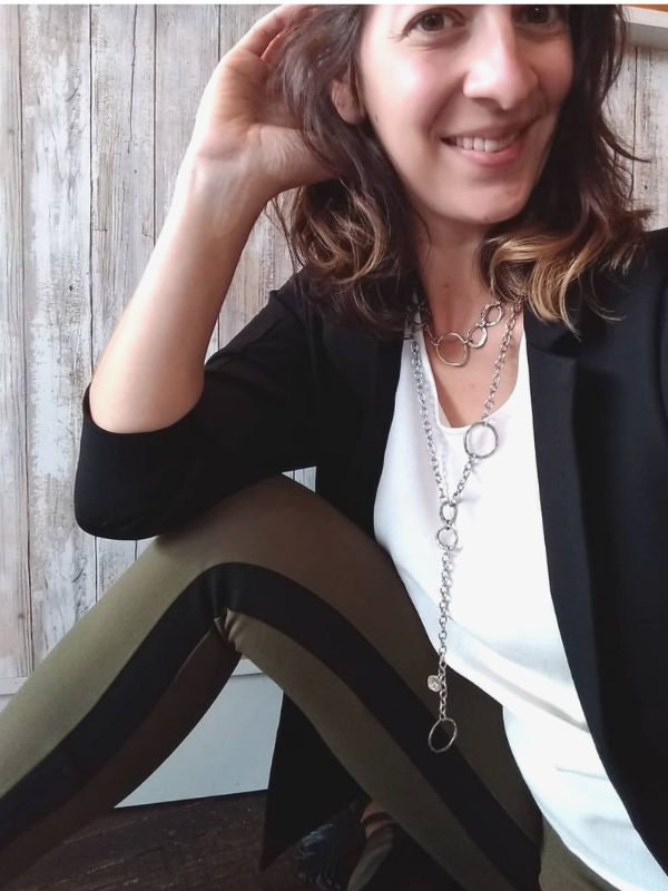 female in blazer with statement necklaces